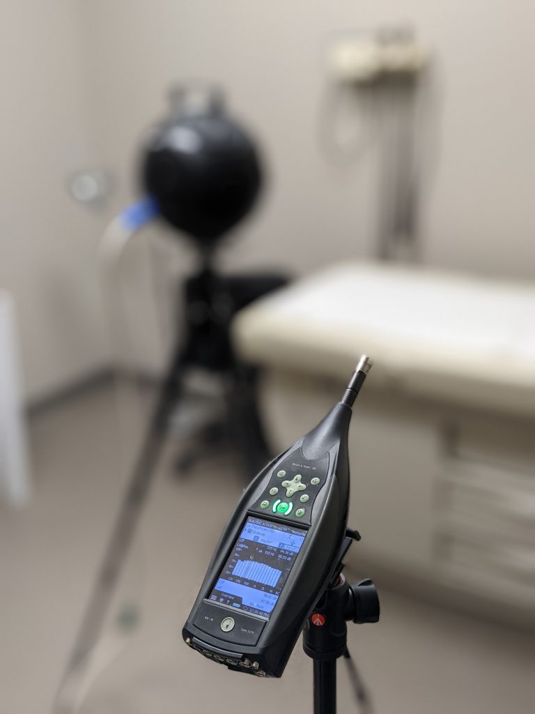 Brüel & Kjær sound analyzer on a tripod during indoor acoustic testing